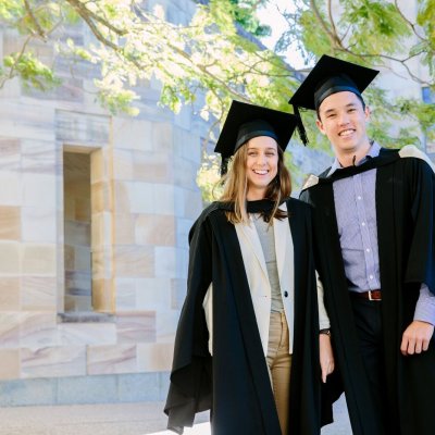 Spot the plastic bottles: The new graduation gowns at UQ are made from 100 per cent recycled plastic bottles. Modelled by July graduating students Hannah Hardy and Casey Fung.